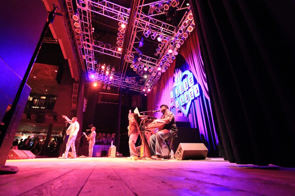 Band members of The Painted Man play on well lit stage for House of Blues performance